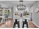 Kitchen island featuring stone countertops, modern seating, and stainless steel appliances with a view to the dining area at 5850 E 54Th Pl, Indianapolis, IN 46226