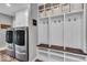 Organized mudroom featuring washer, dryer, hooks, bench, shelves, and baskets for storage at 5850 E 54Th Pl, Indianapolis, IN 46226