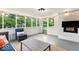 Bright sunroom with white brick walls, string lights, and views of the green backyard at 5850 E 54Th Pl, Indianapolis, IN 46226