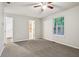 Neutral bedroom featuring a gray carpet, a ceiling fan, and a view of the trees at 5935 Oakforge Ln, Indianapolis, IN 46254