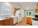 Bright kitchen featuring wood cabinets, white appliances, and a view into the living room at 5935 Oakforge Ln, Indianapolis, IN 46254