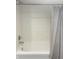 Clean bathtub and shower featuring white tiling and a gray striped shower curtain at 597 W Adams St, Franklin, IN 46131