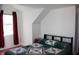 Carpeted bedroom features a window with maroon curtains and attic ceiling at 6052 N Deckshire Ln, Shirley, IN 47384