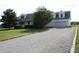 Exterior view of white home featuring an attached garage and a long gravel driveway at 6052 N Deckshire Ln, Shirley, IN 47384