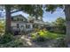 Serene backyard featuring a wooden deck, mature trees, lush greenery, and a charming garden area at 622 N Dequincy St, Indianapolis, IN 46201