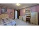 A light pink bedroom with vintage furniture, featuring a framed poster and doorway at 622 N Dequincy St, Indianapolis, IN 46201