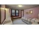 A tranquil pink bedroom with vintage furniture, featuring a view of a sunlit window at 622 N Dequincy St, Indianapolis, IN 46201