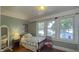 A bright green bedroom with windows, featuring hardwood floors and vintage furniture at 622 N Dequincy St, Indianapolis, IN 46201