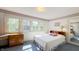 Bright bedroom with three large windows, wood floors, and a closet with mirrored door at 622 N Dequincy St, Indianapolis, IN 46201