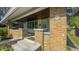 Inviting front porch with classic brick columns, ample seating, and a community sign at 622 N Dequincy St, Indianapolis, IN 46201