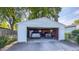 View of two vehicles parked inside detached single-car garage with open door and white siding at 622 N Dequincy St, Indianapolis, IN 46201