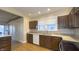 Galley kitchen with window, stainless steel sink, wood cabinets, and tile backsplash at 622 N Dequincy St, Indianapolis, IN 46201