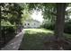 Secluded backyard with a lush lawn, mature trees, and a view of the house at 633 N East St, Greenfield, IN 46140
