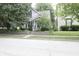 Charming home featuring mature trees, a well-manicured lawn, and a welcoming front porch at 633 N East St, Greenfield, IN 46140
