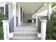 Inviting covered front porch with classic railing and concrete steps at 633 N East St, Greenfield, IN 46140