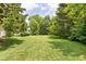 Lush green backyard featuring mature trees, offering a serene and shaded outdoor space at 6429 Walnut Way, Brownsburg, IN 46112