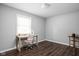 Bright bedroom featuring a window, a desk, neutral walls, and wood-look floors for a simple workspace at 6429 Walnut Way, Brownsburg, IN 46112