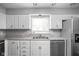 Well-lit kitchen featuring white cabinets, stainless steel appliances, and a bright window over the sink at 6429 Walnut Way, Brownsburg, IN 46112
