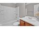 Bright bathroom featuring a white tiled shower-tub and a wooden vanity with white countertops at 652 White Ash Trl, Mooresville, IN 46158