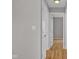 Hallway with hardwood floors and neutral-colored walls, illuminated by a flush mount light at 652 White Ash Trl, Mooresville, IN 46158