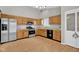 Well-lit kitchen featuring stainless steel appliances, wood cabinetry, and granite countertops at 652 White Ash Trl, Mooresville, IN 46158