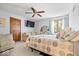 Cozy bedroom features a comfortable bed, ceiling fan, and view to the backyard at 7250 Royal Oakland Dr, Indianapolis, IN 46236