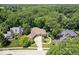 Charming ranch-style home nestled amongst lush trees in a well-manicured neighborhood with mature plantings and curved driveway at 7250 Royal Oakland Dr, Indianapolis, IN 46236
