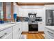 Bright kitchen showcasing white cabinets, modern stainless steel appliances, and hardwood floors at 7250 Royal Oakland Dr, Indianapolis, IN 46236