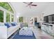 Living room with large windows, ceiling fan, light colored paint, and access to the outdoor deck at 7250 Royal Oakland Dr, Indianapolis, IN 46236