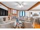 Cozy living room boasts a brick fireplace, ceiling fan, hardwood flooring and wainscotting at 7250 Royal Oakland Dr, Indianapolis, IN 46236