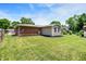 Large backyard featuring a well-kept lawn, brick home, and extension with meticulous landscaping, and chain link fence at 734 Summitcrest Dr, Indianapolis, IN 46241