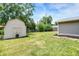 Large backyard features a lush lawn, shed, and a landscaped area with dark mulch, perfect for Gathering enjoyment at 734 Summitcrest Dr, Indianapolis, IN 46241