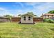 A well-maintained backyard with a green lawn, brick house, and a small extension with black mulch at 734 Summitcrest Dr, Indianapolis, IN 46241