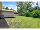 Expansive backyard featuring lush green grass, shed, mulch landscaping, and potential for various outdoor activities at 734 Summitcrest Dr, Indianapolis, IN 46241
