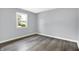 Neutral bedroom features gray wood-look flooring and natural light from a window at 734 Summitcrest Dr, Indianapolis, IN 46241