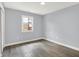 A small, empty bedroom has laminate flooring and a window with an outside view at 734 Summitcrest Dr, Indianapolis, IN 46241