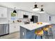 A well-equipped kitchen features an island with barstool seating, stainless steel appliances and sleek white cabinetry at 734 Summitcrest Dr, Indianapolis, IN 46241