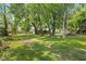 Spacious backyard with green grass, mature trees and views of the house and surrounding neighborhood at 761 N Holmes Ave, Indianapolis, IN 46222