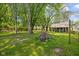 Spacious backyard with green grass, mature trees, and a view of the back of the house at 761 N Holmes Ave, Indianapolis, IN 46222