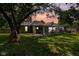 Exterior of home with covered back patio and grassy backyard under the shade of a large tree at 761 N Holmes Ave, Indianapolis, IN 46222