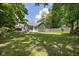 Spacious backyard with lush green grass and mature trees, providing privacy and shade at 761 N Holmes Ave, Indianapolis, IN 46222