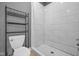 Modern bathroom featuring white tile shower with hexagon tile base and black metal shelving at 761 N Holmes Ave, Indianapolis, IN 46222