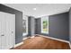 Bedroom featuring gray walls, wood floor, two windows and a closet behind a white door at 761 N Holmes Ave, Indianapolis, IN 46222