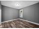 Comfortable bedroom featuring hardwood floors, neutral gray walls, and a window at 761 N Holmes Ave, Indianapolis, IN 46222