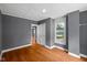 Bedroom with hardwood floors, grey walls, a window with natural light and a white closet door at 761 N Holmes Ave, Indianapolis, IN 46222
