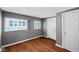 Bedroom with gray walls, wood floor, and two windows with blinds plus white doors at 761 N Holmes Ave, Indianapolis, IN 46222