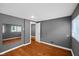 Bedroom with gray walls, wood floor, mirror, and two doorways plus one window at 761 N Holmes Ave, Indianapolis, IN 46222