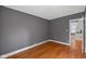 Bedroom features wood flooring, neutral walls, white trim, and an open doorway to another room at 761 N Holmes Ave, Indianapolis, IN 46222