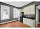 Bright kitchen with white cabinetry, black countertops, backsplash, and stainless steel appliances at 761 N Holmes Ave, Indianapolis, IN 46222