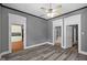 Hardwood floored living room, boasting gray walls, white trim, and open access to the kitchen and hallway at 761 N Holmes Ave, Indianapolis, IN 46222